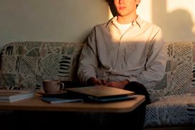 Молодой мужчина сидит на диване